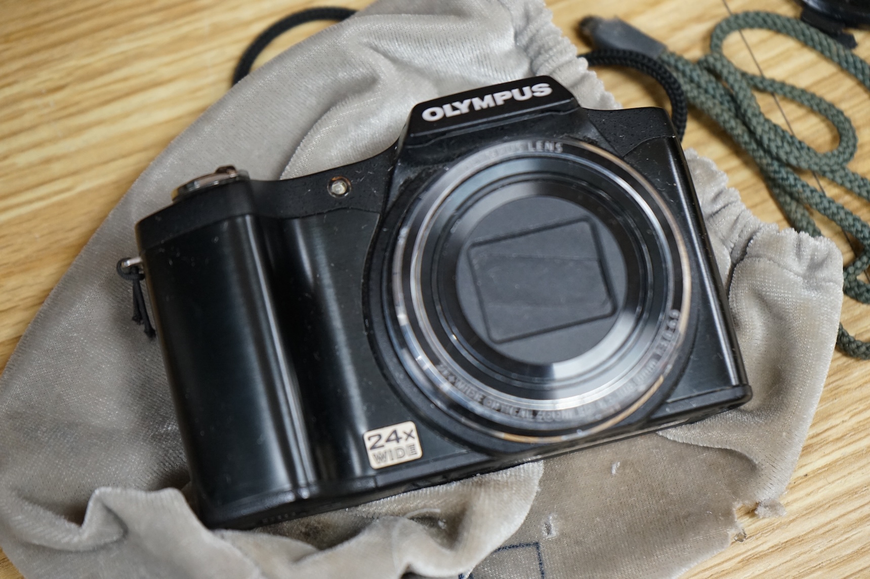 A cased Olympus 35SP camera, together with two more recent digital cameras